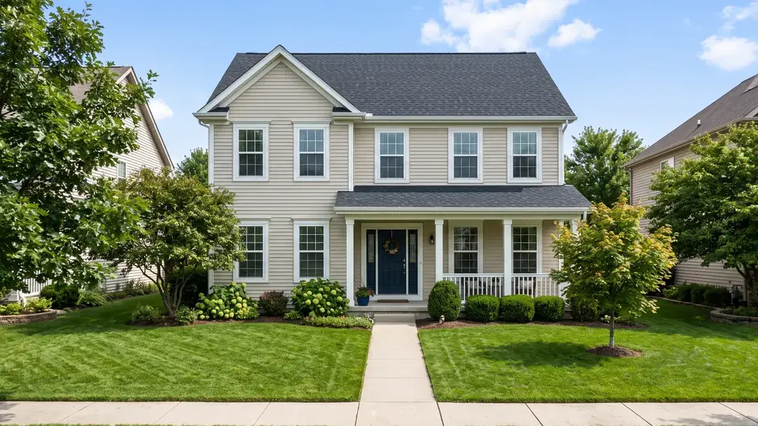 The same house with a new roof, a clear lawn and blue sky